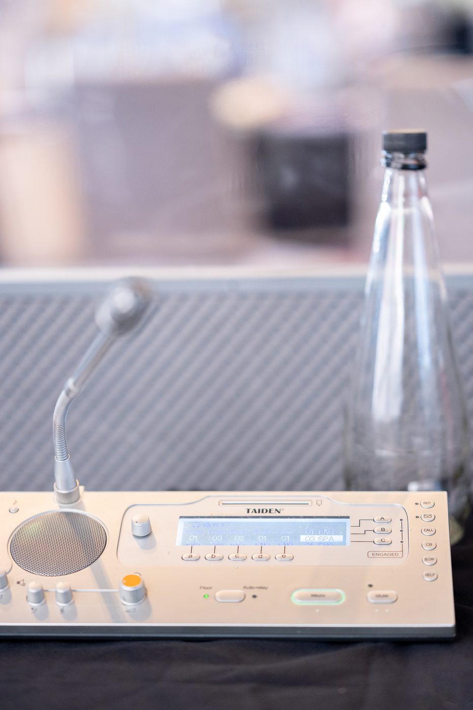 Close-up of a Taiden interpreter console showing channel selectors and gooseneck microphone