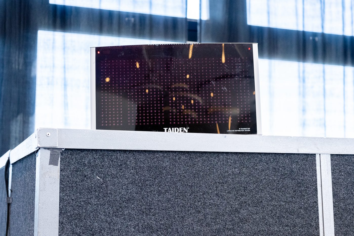 Close-up of a Taiden IR language distribution transmitter mounted on an interpretation booth